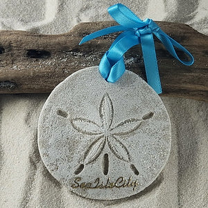 Sea Isle City gift idea.  Real sand is used to create this sand dollar ornament.  it is whitewashed, glittered and on the bottom are gold scripted lettering reading Isle of Palms.  Attached is a pretty turquoise bowed ribbon for hanging and a tag indicating that it is handcrafted with sand and made in the USA.